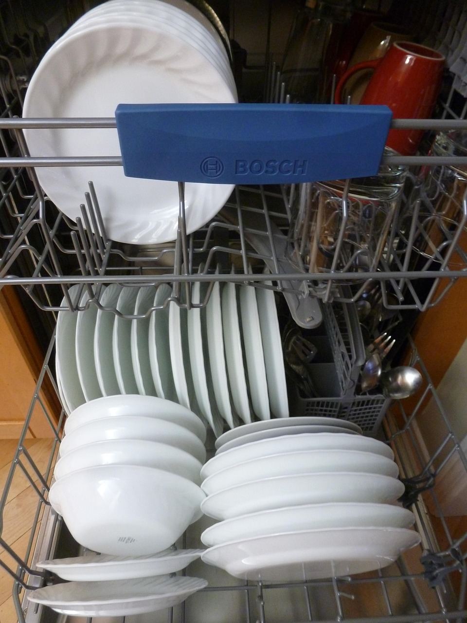 Intérieur d’un lave-vaisselle domestique ouvert avec sa vaisselle visible